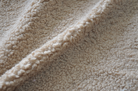 Le polyester 100% beige de sherpa de faux ou avec l'onde entretenue de la laine 150cm ou la chaîne réglable a tricoté le tissu réutilisé