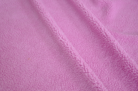 La chaîne de laine du rose 150cm a tricoté le tissu pour des manteaux et des dessus